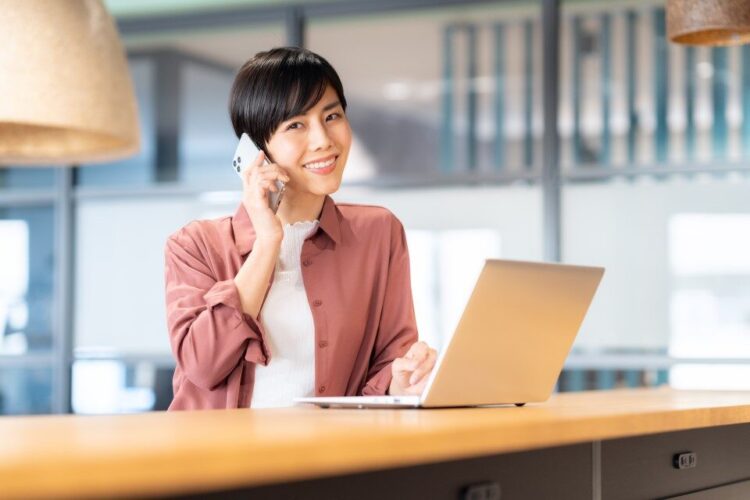 笑顔でIVR電話に対応する若い女性